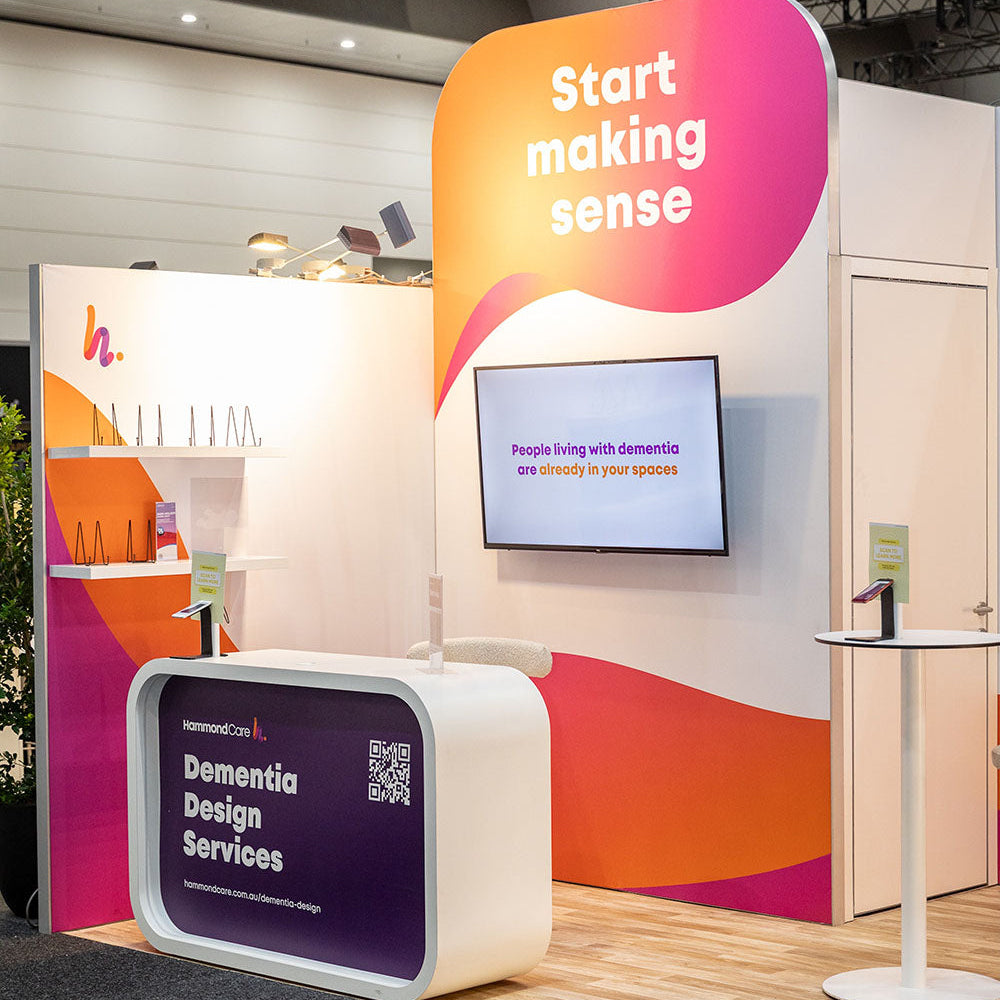 Exhibition stand with 'Start making sense' and 'Dementia Design Services' branding.