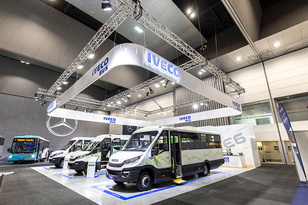 IVECO display at an exhibition with buses and trucks.