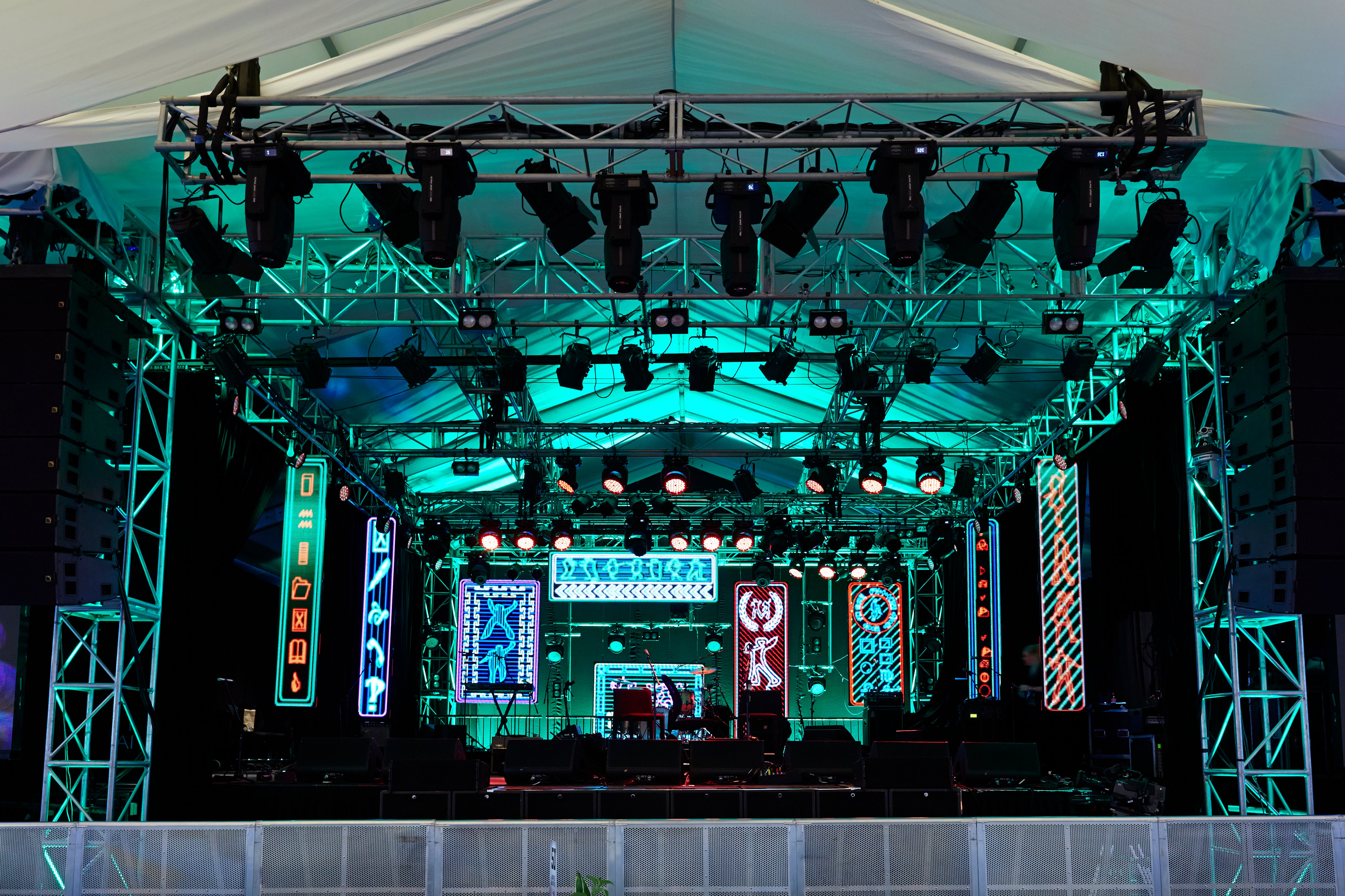 Stage setup with lighting equipment and digital screens at a concert venue.