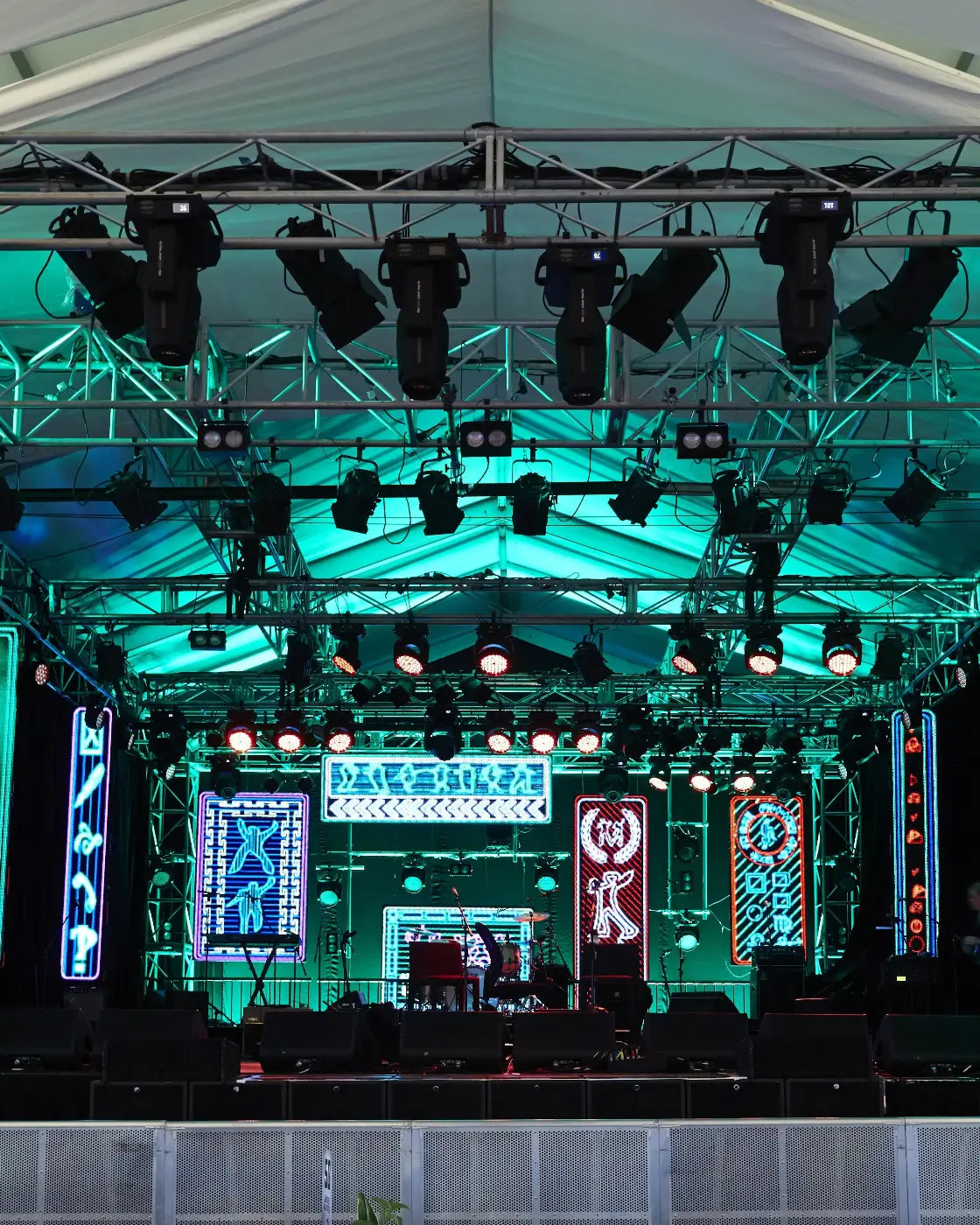Stage with lighting equipment and colorful screens at a concert or event.