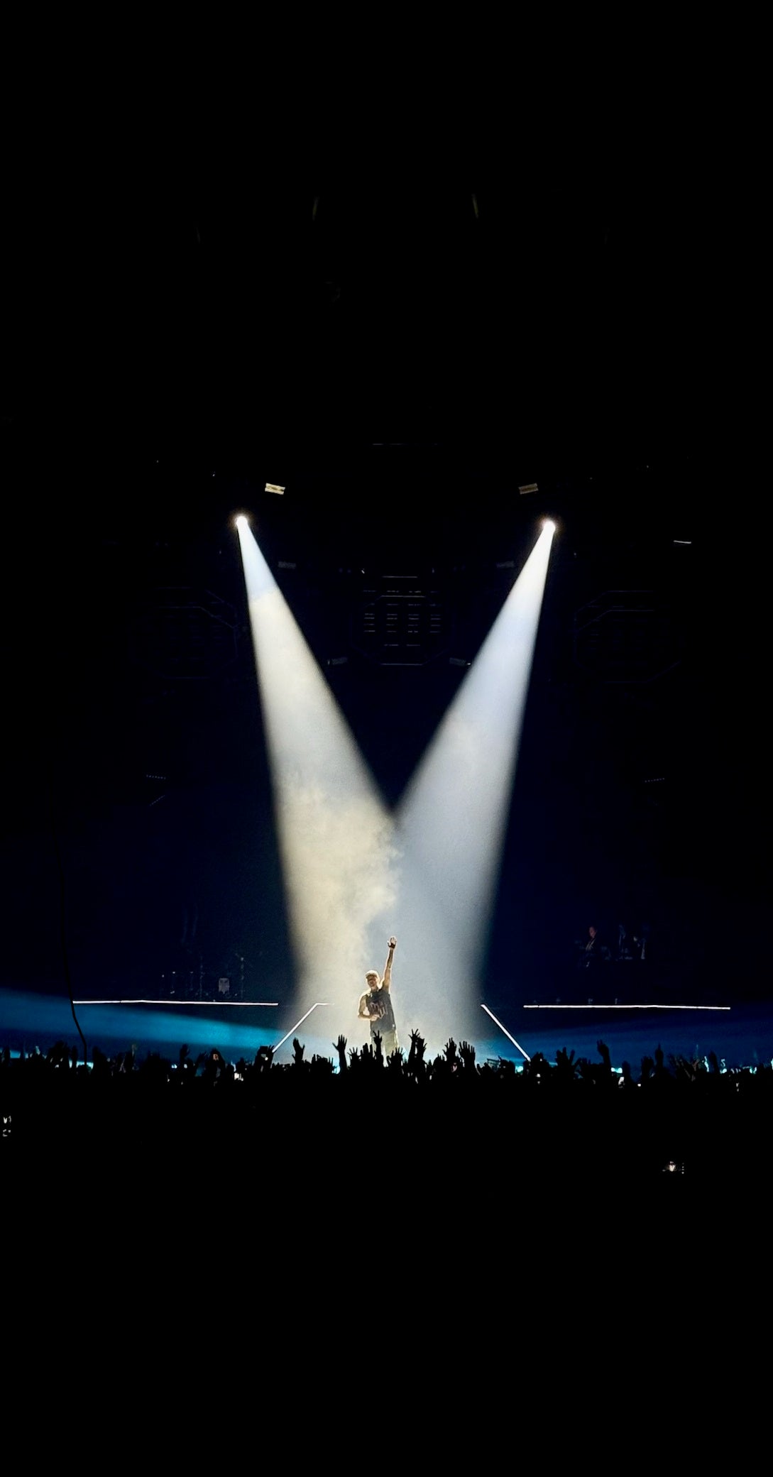 Person on stage with two spotlights from above, dark background