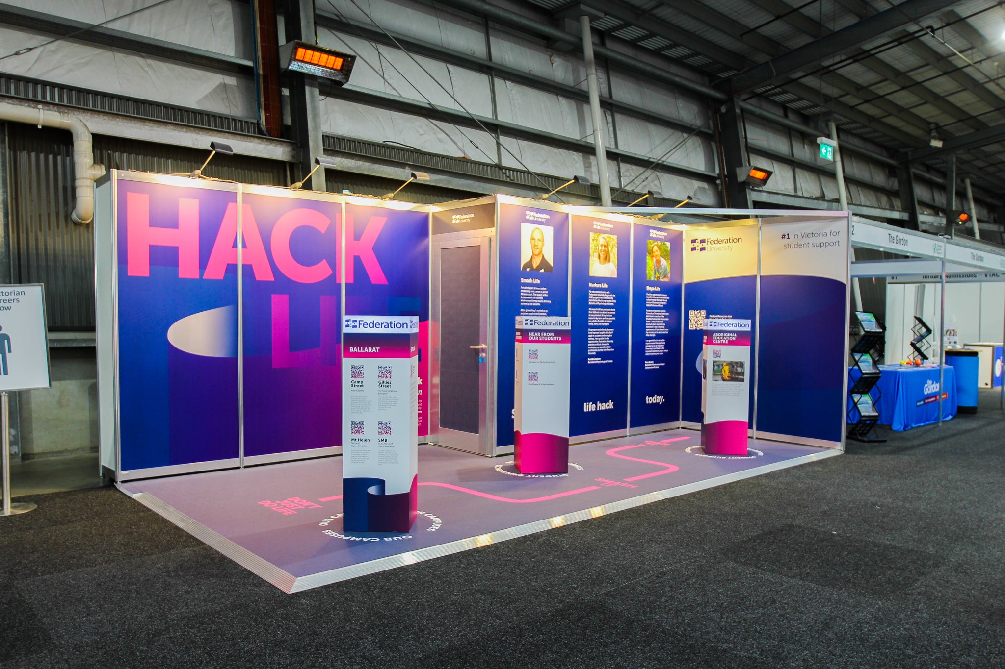 Exhibition stand with 'HACK' branding in a large indoor space.