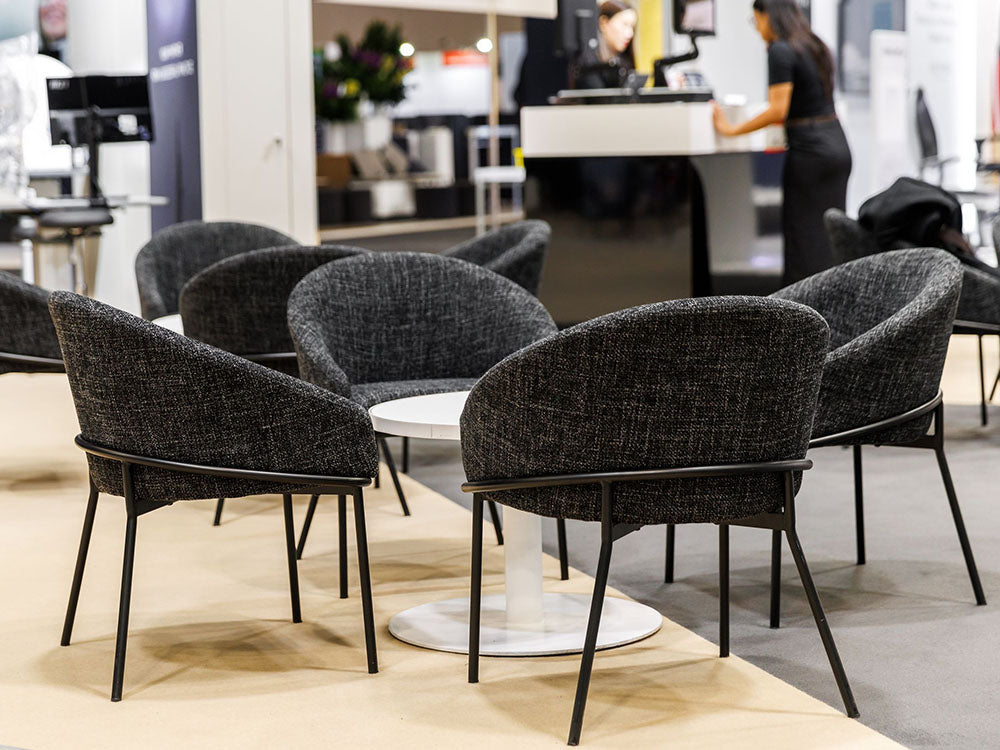 Gray chairs around a white table in an indoor setting with blurred background