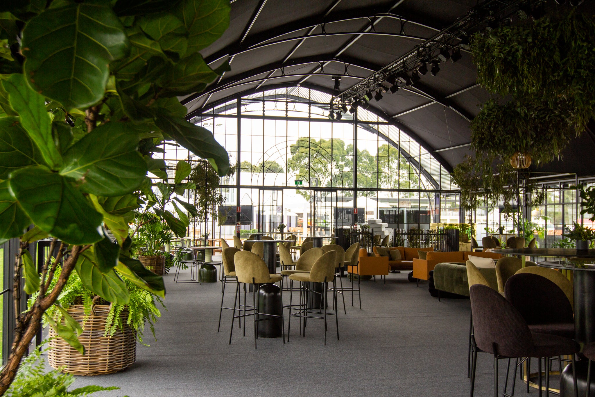 Modern indoor setting inside our Atrium with large windows, chairs, and plants for a private event.