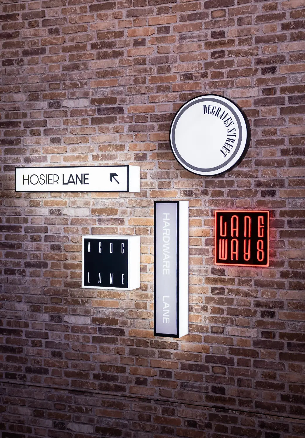 Faux brick wall with various illuminated signs 