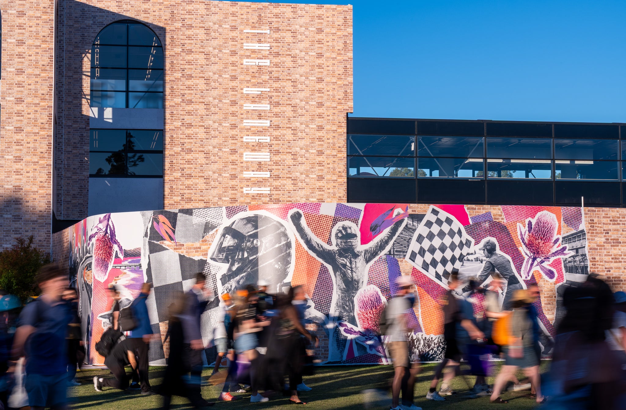 Mural on a building with people walking by