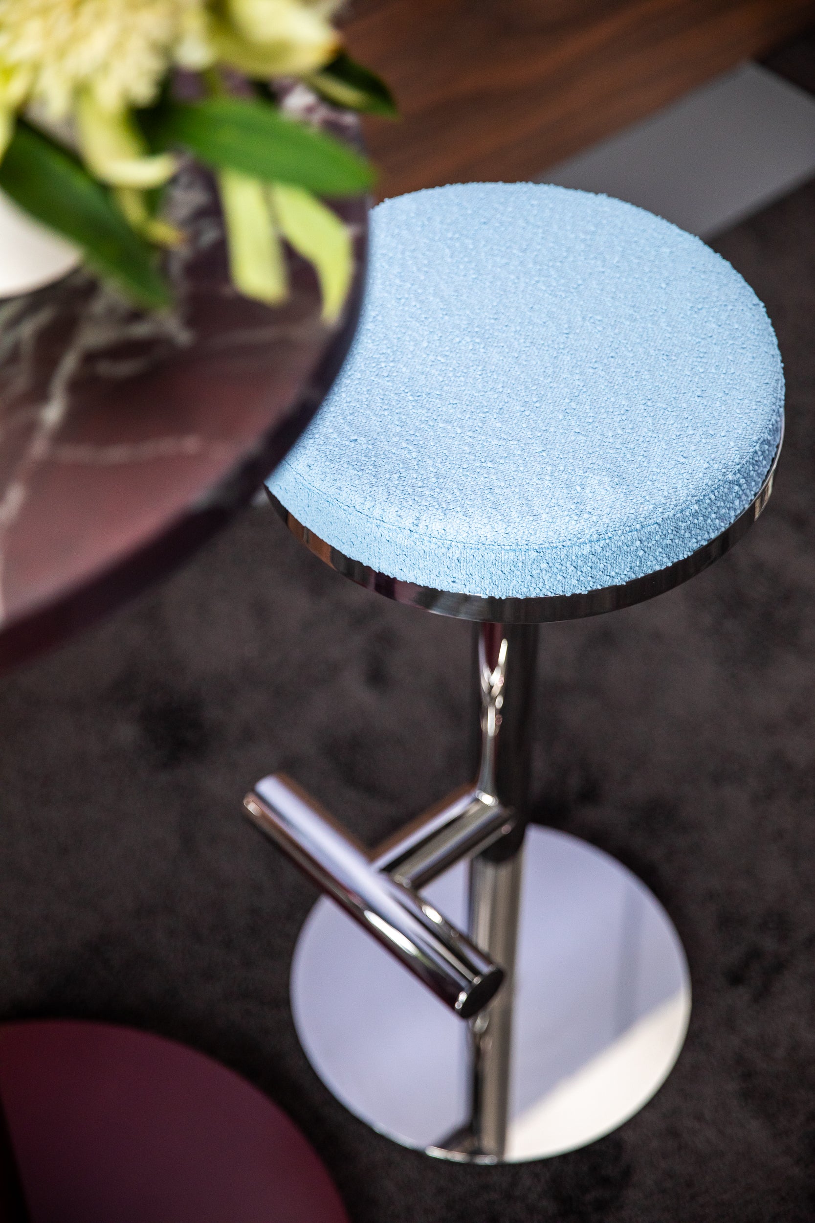 Blue bar stool with chrome base in a casual setting
