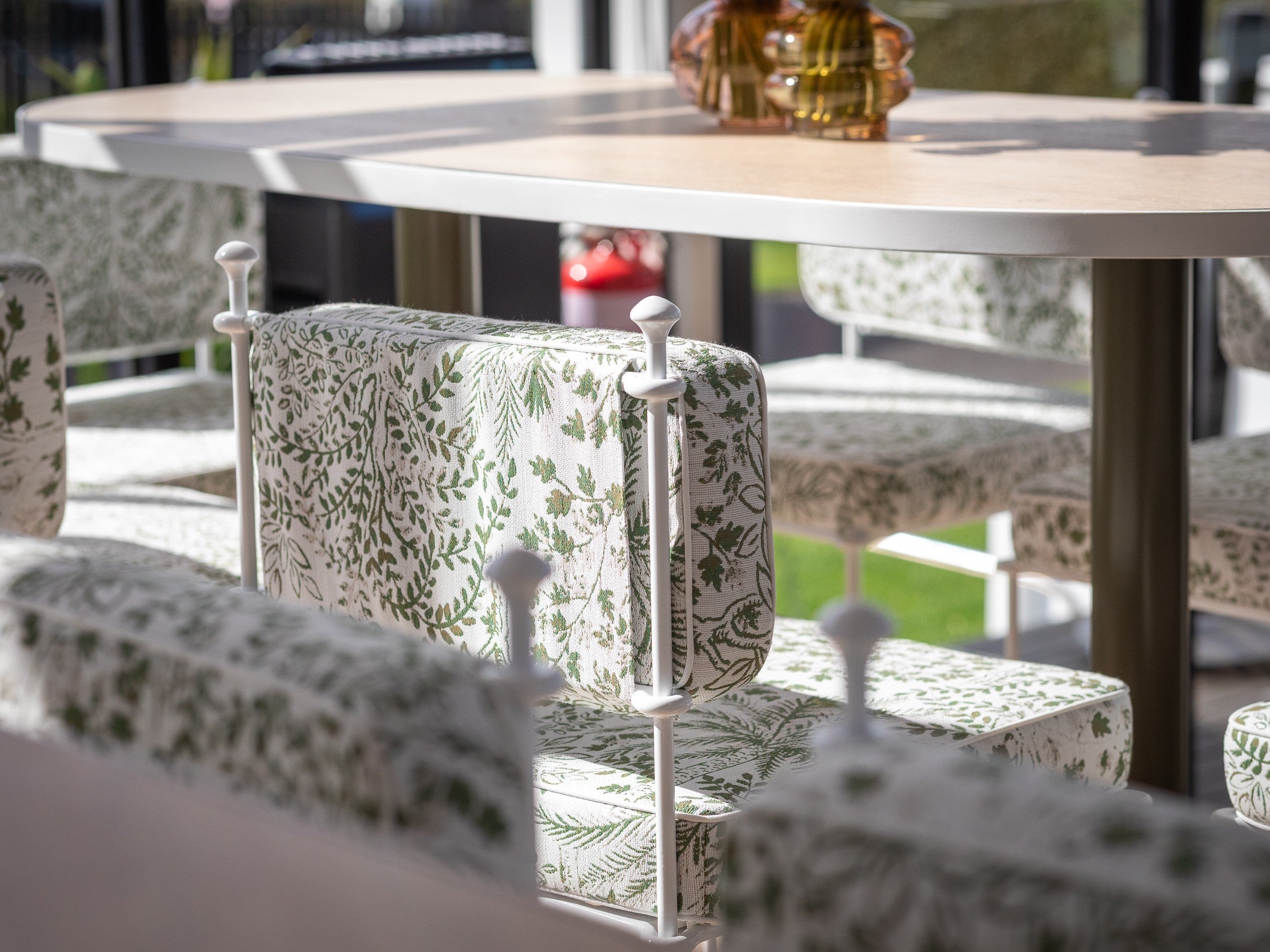 Outdoor hire furniture set with patterned chairs and tables on a patio. Pictured; Gigi