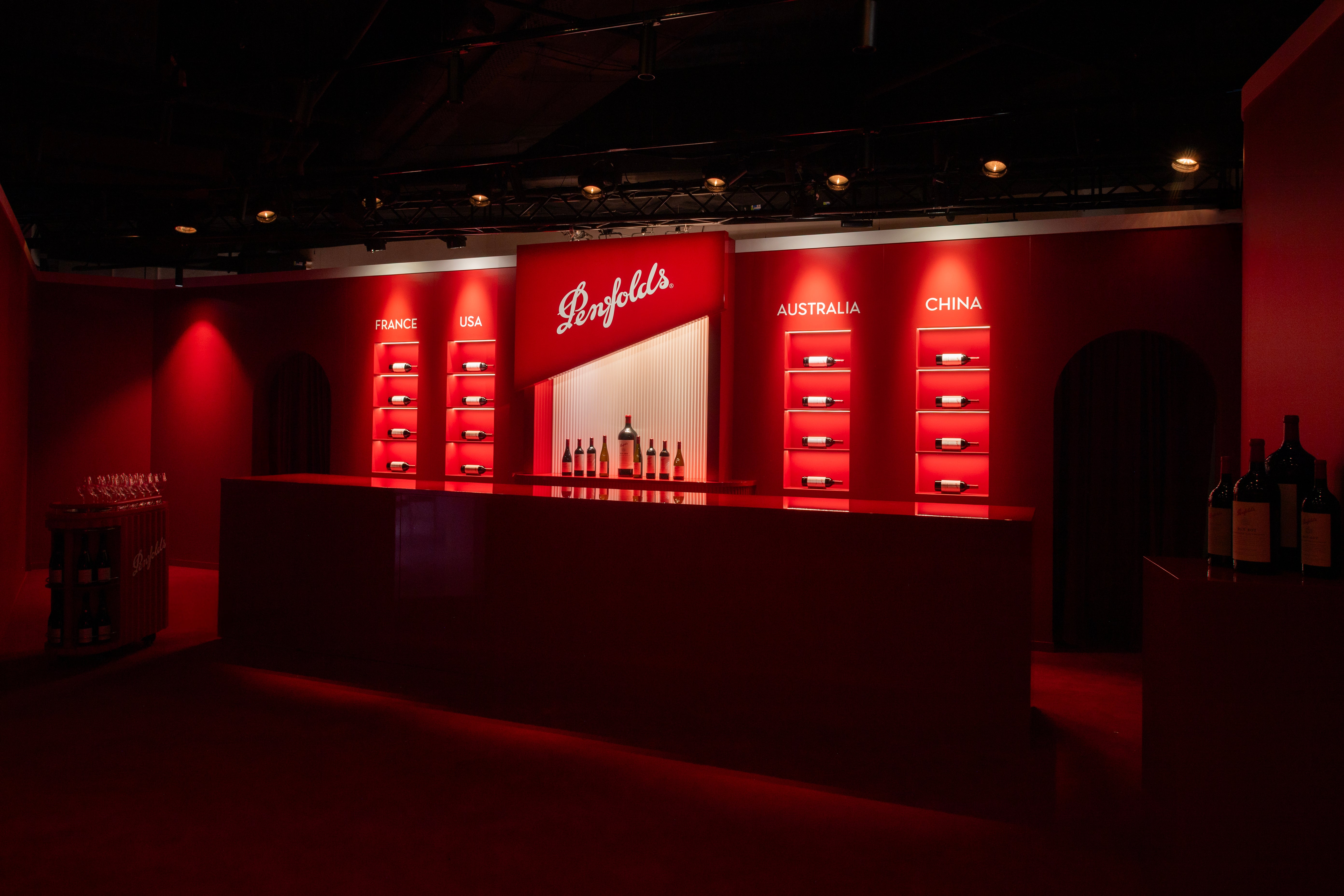 Penfolds display with red walls and custom branding in a dimly lit room.