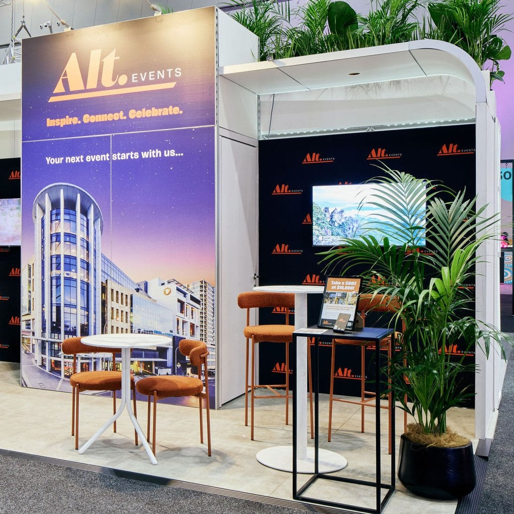 Upgrade expo booth with 'Alt Events' branding, chairs, and a table.