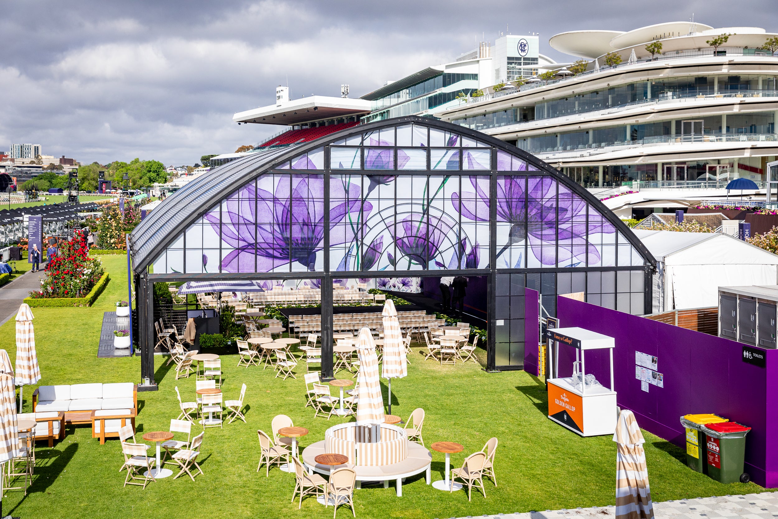 Outdoor event space with the Atrium Marquee and tables on a grassy area at Spring Racing Carnival.