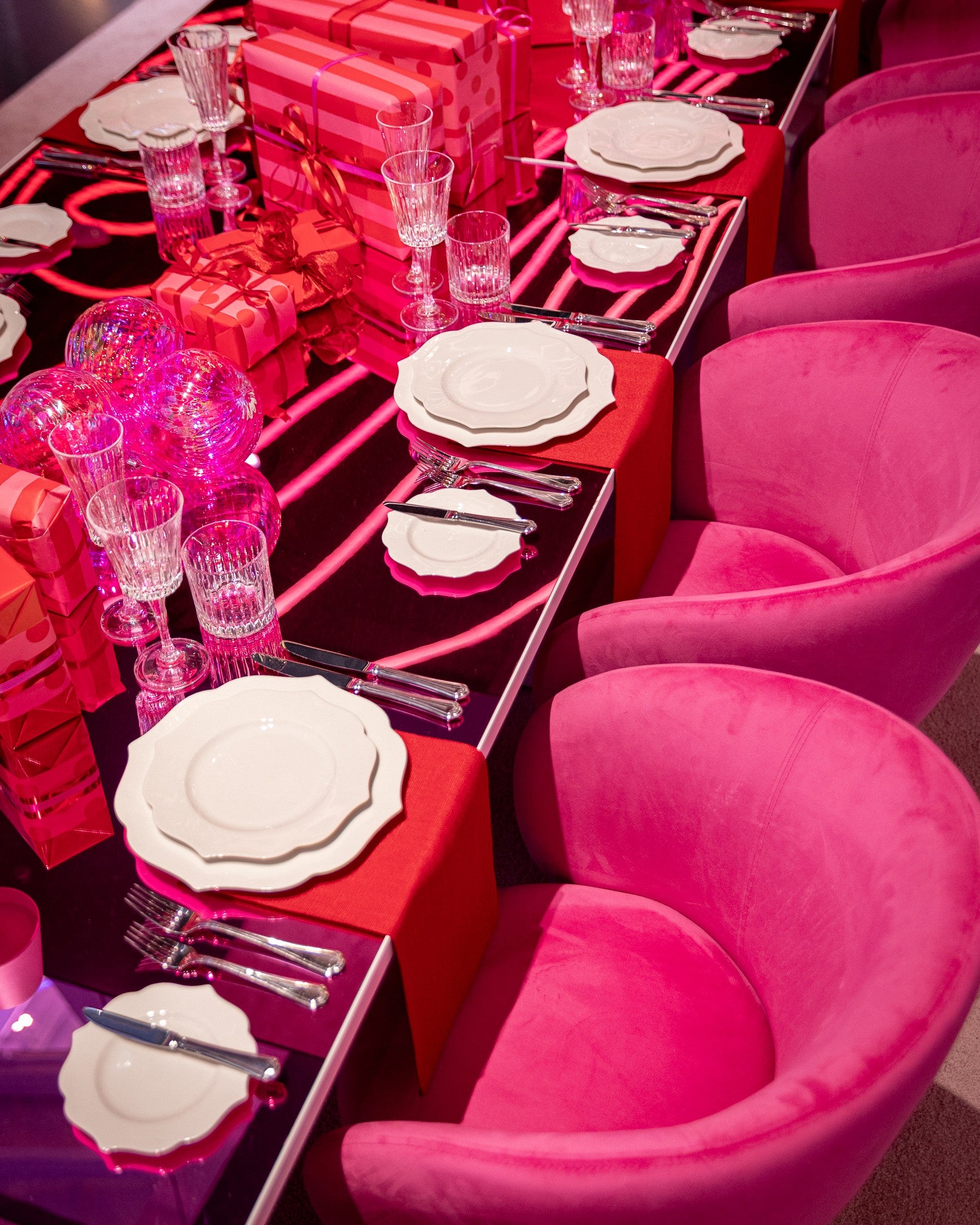 Pink and red table setting with chairs in a vibrant room. Shot in our Showroom in Melbourne