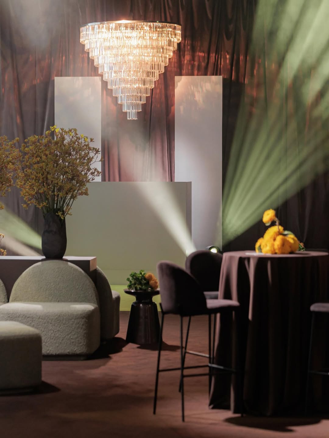 Modern interior design with chandelier, tables, and decorative elements.