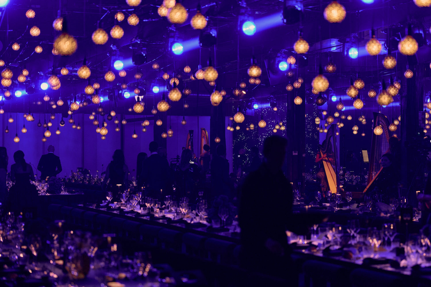 Indoors gala dinner with purple lighting and hanging lights